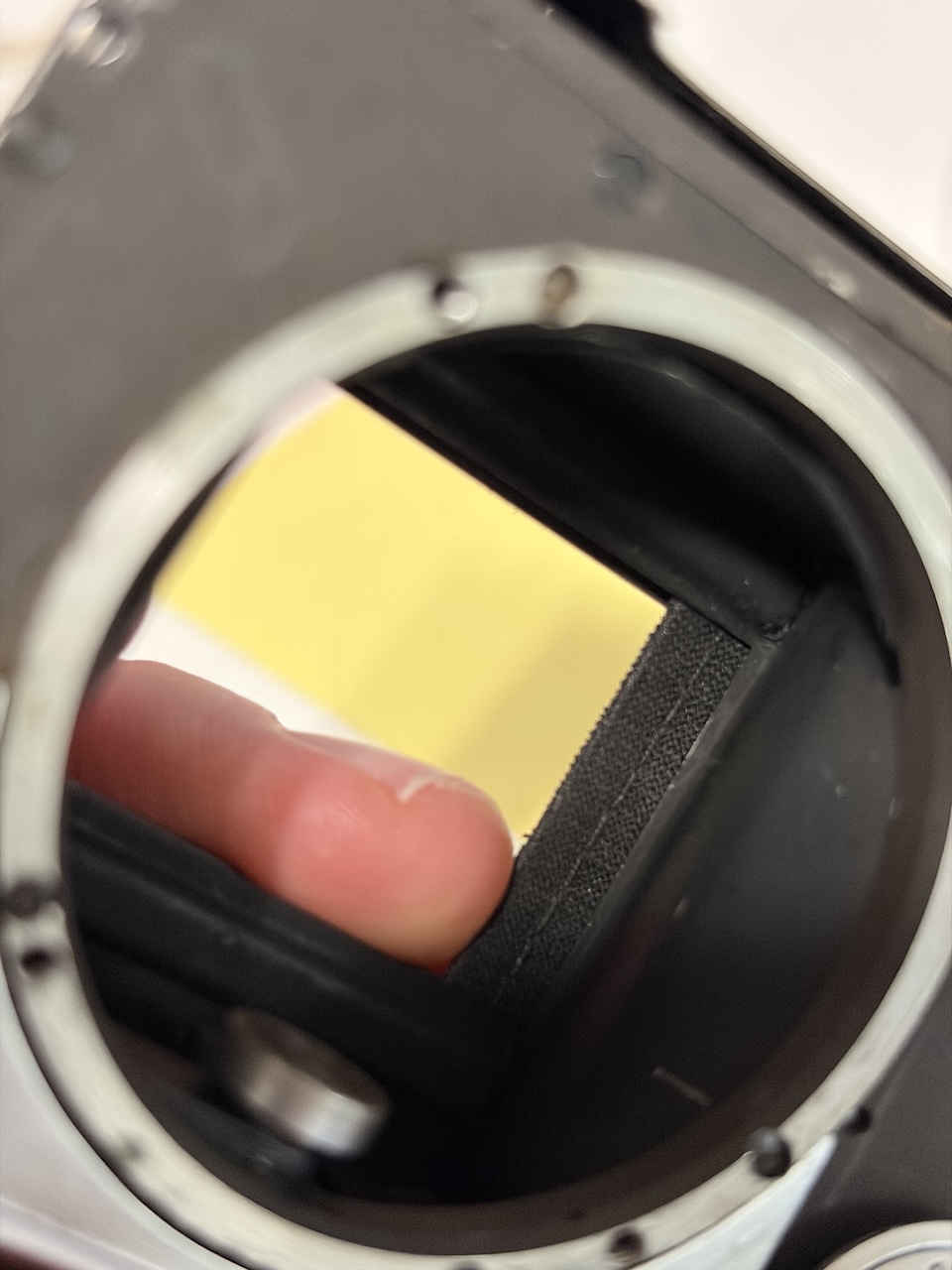 The Leica in close, a finger showing where the edges of the shutter were visibly frayed.