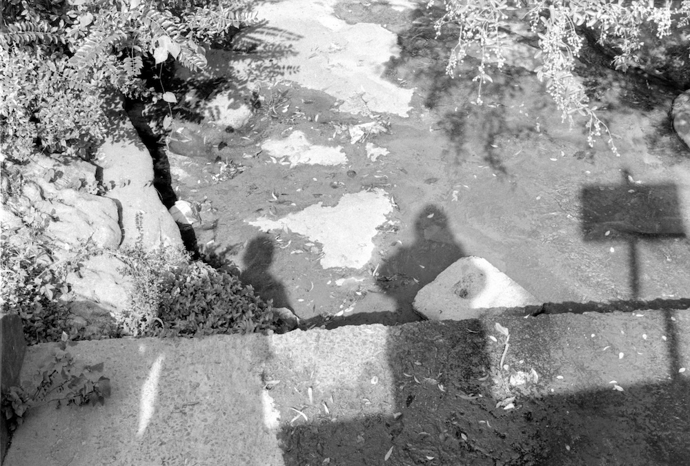 One of the first photos taken by the blog author. The silhouettes of her and one of her friends are visible, the photo looking down into a storm water drain. Shot on a Pentax Spotmatic on Ilford HP4, circa 1997.