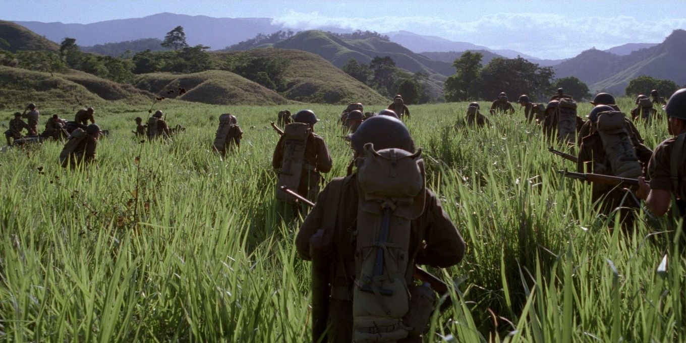 A company of American soldiers walk through tall grass on an island somewhere in the south pacific. The colours are, again, rich and saturated, accentuating the greens and browns.